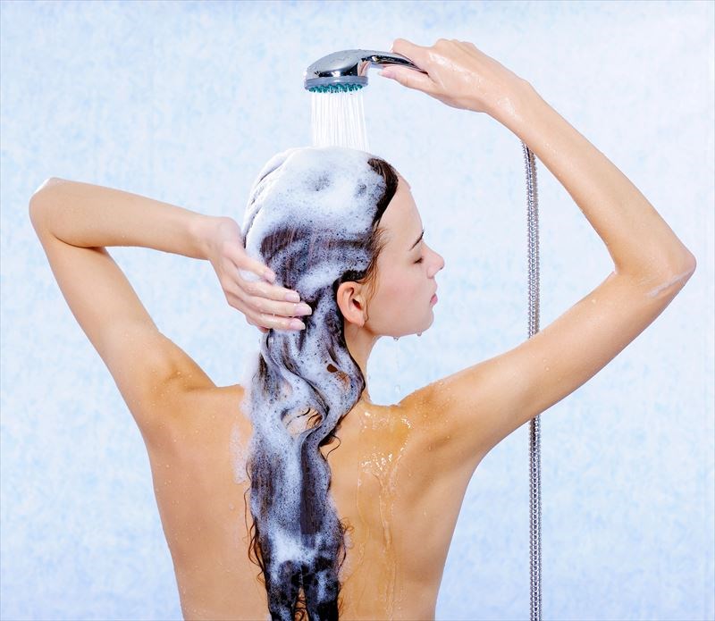 髪をシャンプーして洗い流す女性