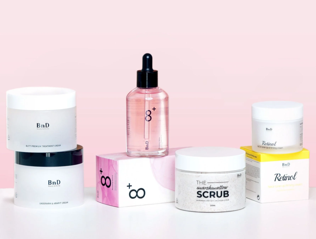 ピンクの背景に並べられた複数のBnDスキンケア製品