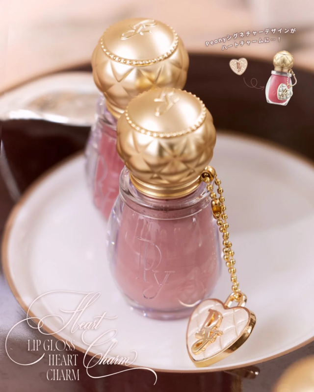 金色のキャップとハートチャームが付いたピンク色のリップグロス