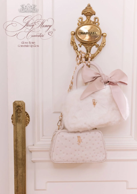 白いドアに掛けられた白いファーバッグとピンクのオーストリッチ柄バッグ