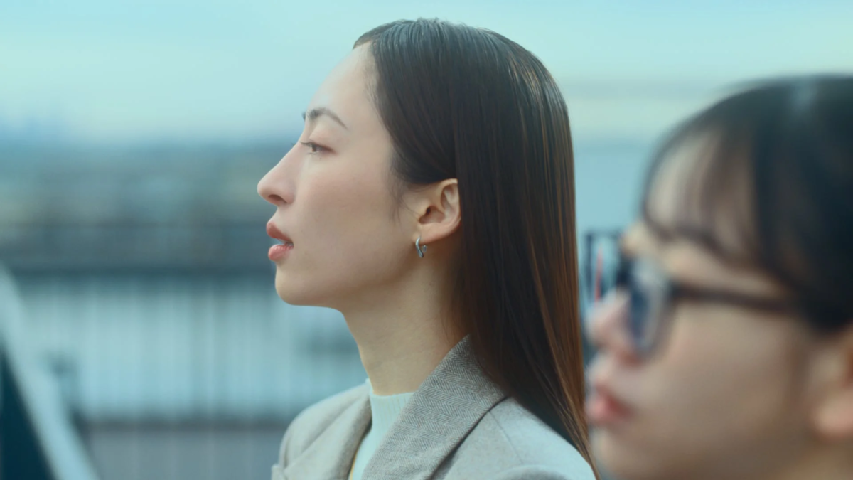 屋外で遠くを見つめる女性の横顔