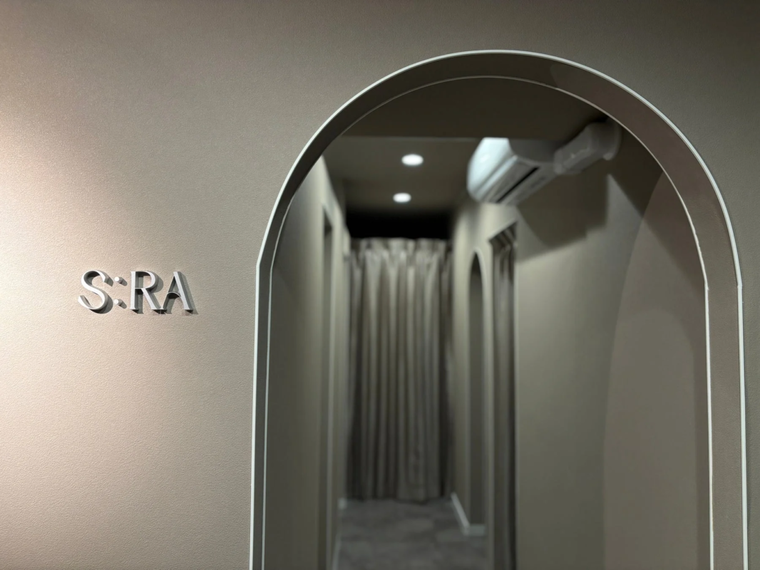 「S:RA」と書かれた壁と、アーチ状の開口部が特徴的なモダンな内装