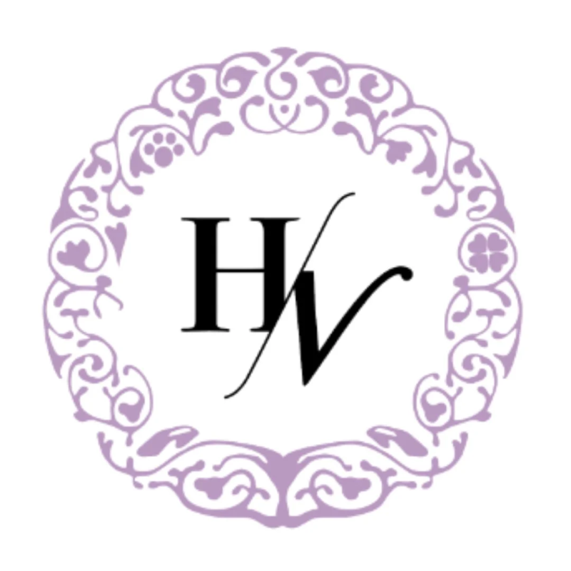 紫色の装飾的なフレームの中に、黒い「H」と「V」のイニシャルが組み合わされたエレガントなロゴマーク