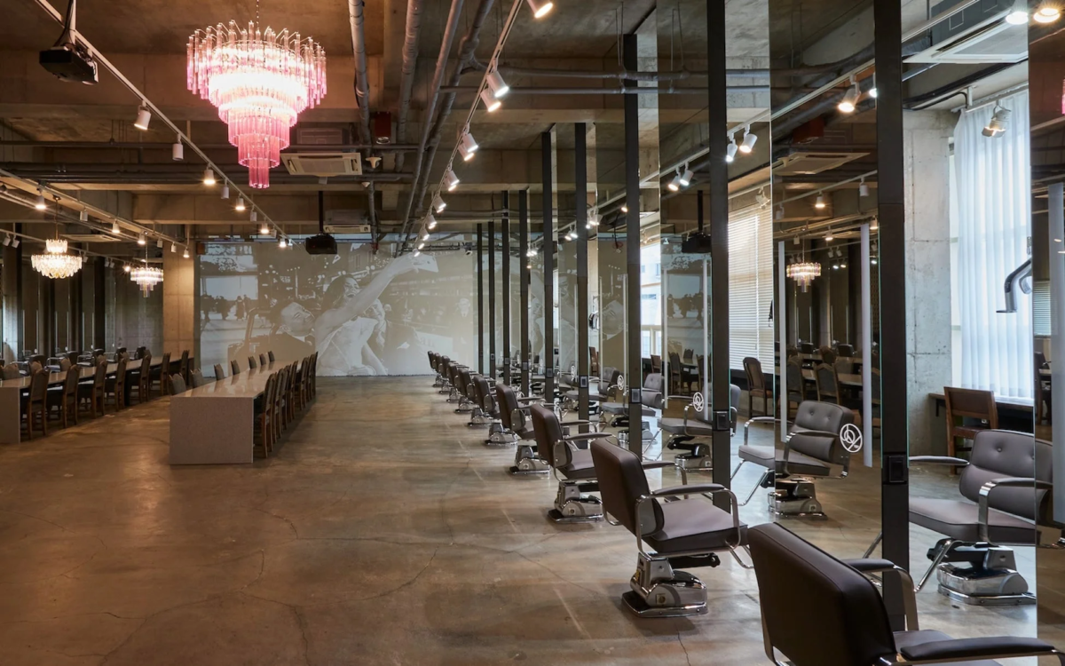 インダストリアルな空間に美容室のような椅子と鏡が並ぶサロン内観