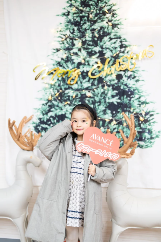 クリスマスツリーの前でポーズをとる女の子