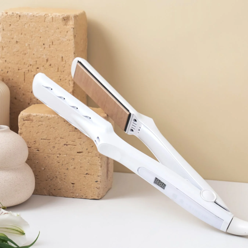白いヘアアイロンが白い台に置かれ、背景にはベージュの壁と装飾的なブロックが見える