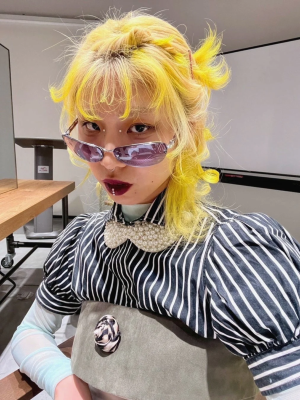 個性的なヘアスタイルとサングラスの女性