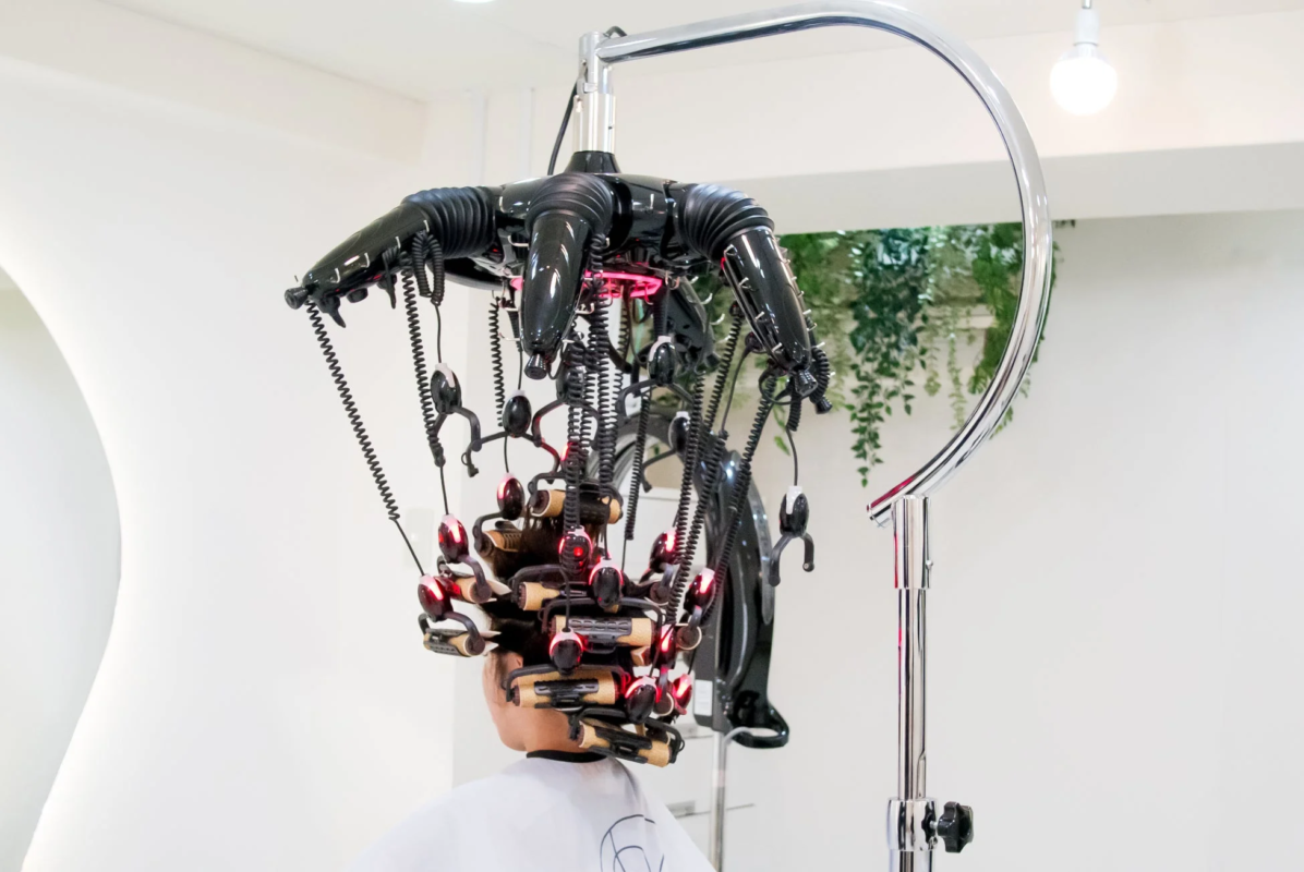 モダンなパーマ機器を装着してヘアトリートメントを受けている様子