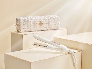 白いヘアアイロンと、ツイード調の白い収納ケースがベージュの台に置かれている製品写真