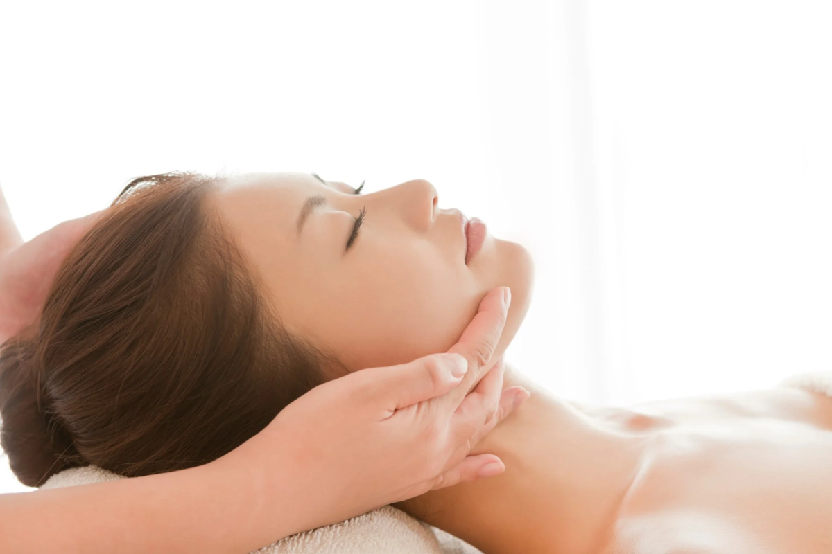 エステサロンでフェイシャルマッサージを受ける女性