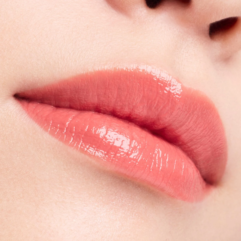 つややかなピーチ色のリップグロスが塗られた唇
