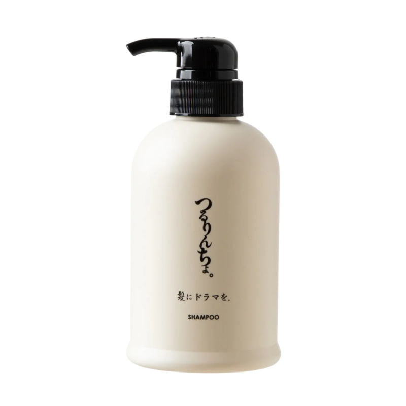 白い背景に置かれた、黒いポンプ式のディスペンサーが付いたクリーム色のシャンプーボトル