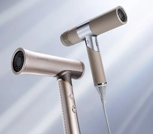 ベージュとゴールドの色合いが特徴的な、スタイリッシュなヘアドライヤーが2台写っています