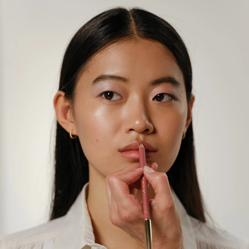 リップライナーを塗る女性の唇のクローズアップ