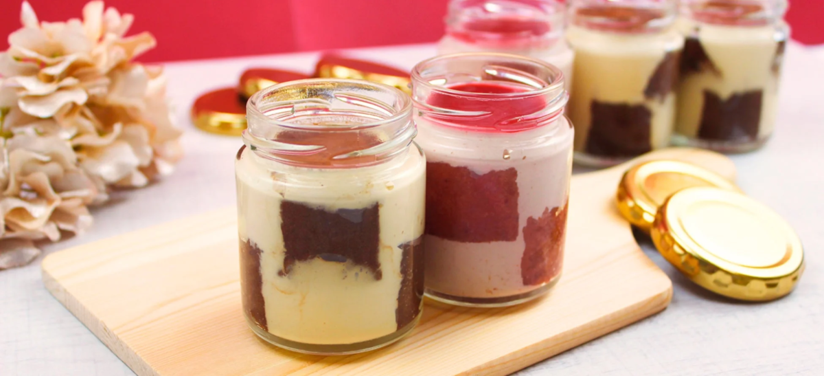 透明な瓶に入った層状のデザートの画像