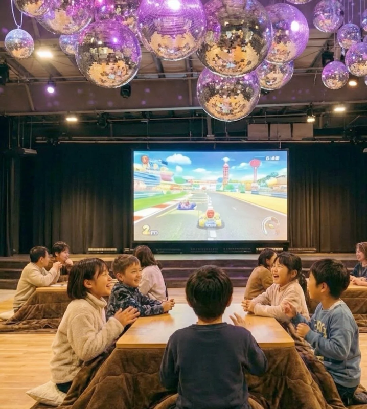 大画面Switchでゲームを楽しむ子供たち