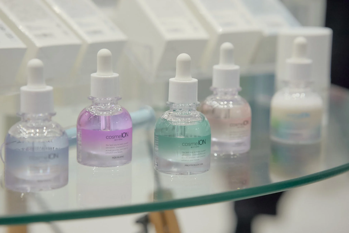 cosmeIONブランドの美容液が並べられたガラス棚