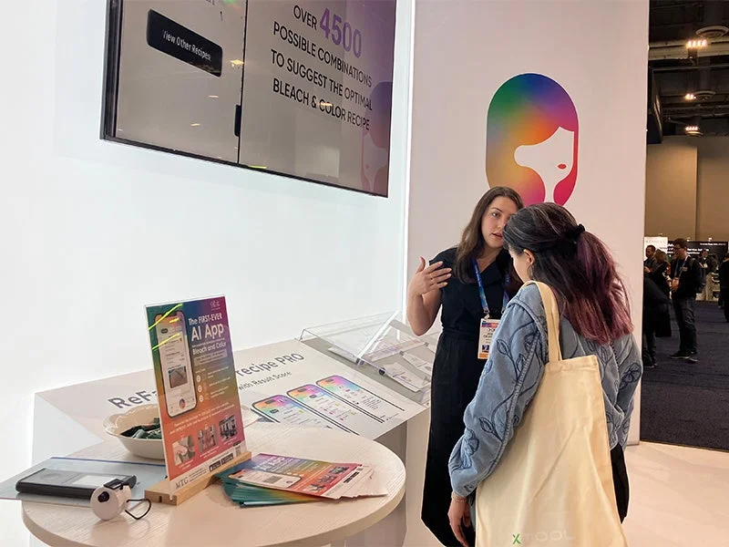 展示会のReFaブースでAIカラーレシピPROを説明する様子