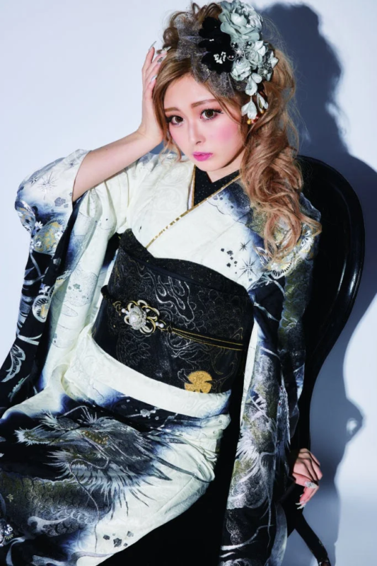 白と黒の龍柄の華やかな振袖をまとった女性