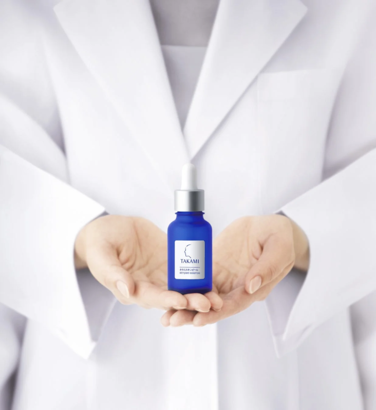 白衣の人物がタカミスキンピールを持つ