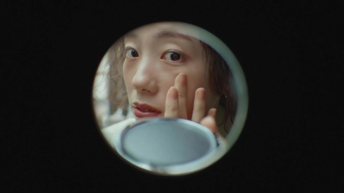 鏡で肌を確認する女性