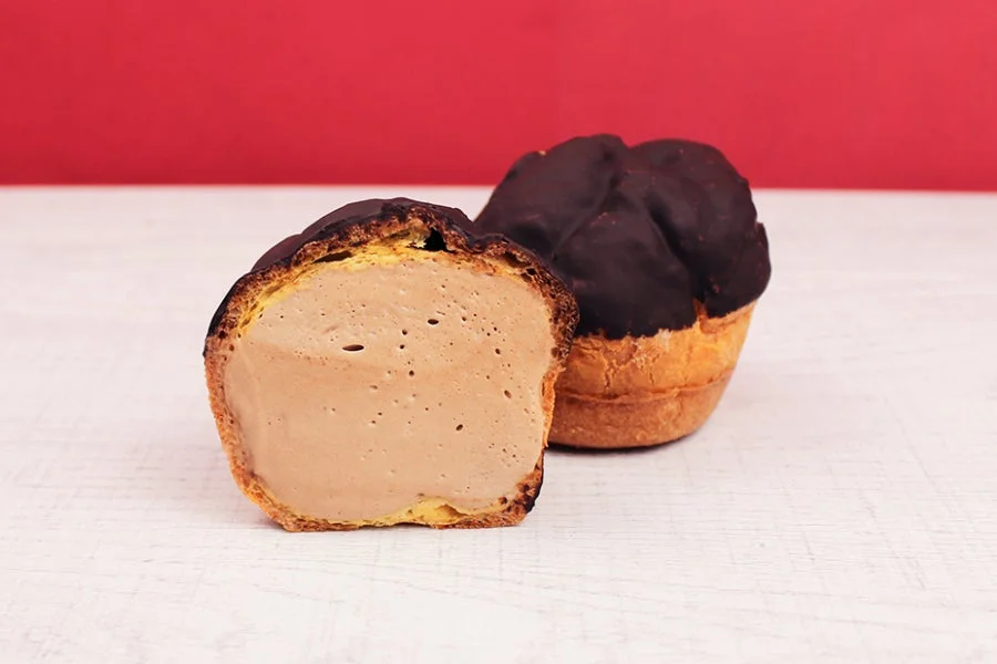 チョコレートがけのシュークリームの断面が見える画像
