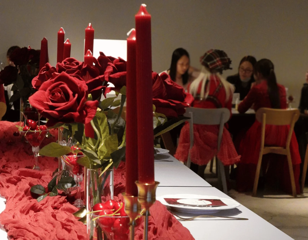 バラやキャンドルで飾られたテーブルで交流する人々