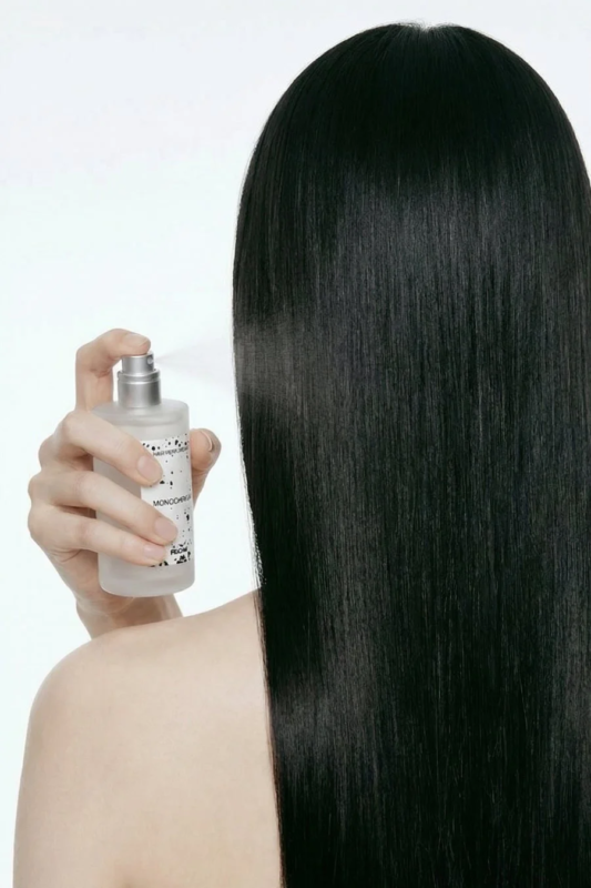 ヘアパフュームをスプレーする女性