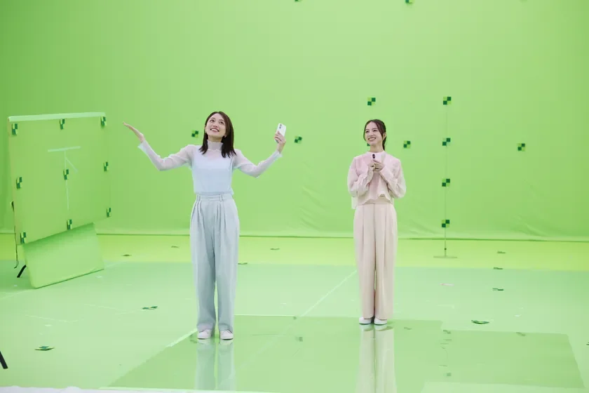 緑色のクロマキースタジオで撮影中の川口春奈さんと清原果耶さん