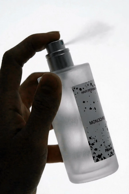 ヘアパフュームをスプレーする手