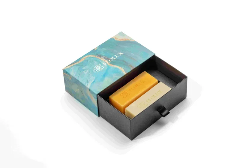 マーブル模様のエレガントな箱に収められた、FIOLUXブランドの黄色とクリーム色の石鹸2個のセット