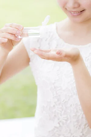 女性が手のひらに液体を注ぐ