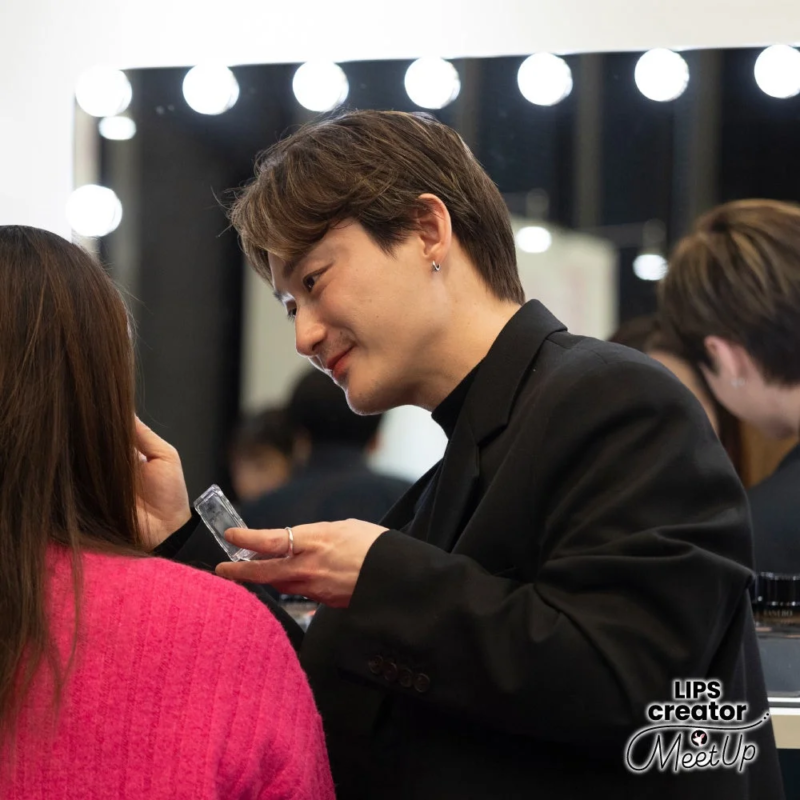 メイクアップアーティストが女性にメイクを施している様子