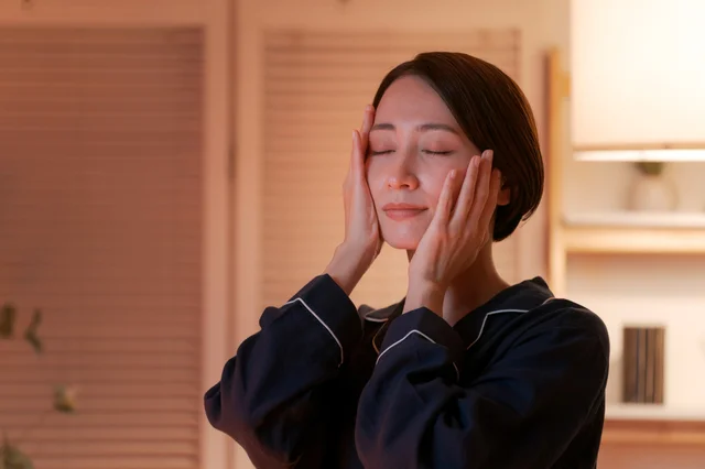 パジャマ姿の女性が顔を包み込む