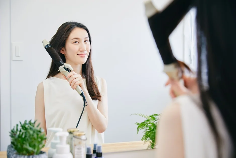 女性がヘアアイロンを使用している様子