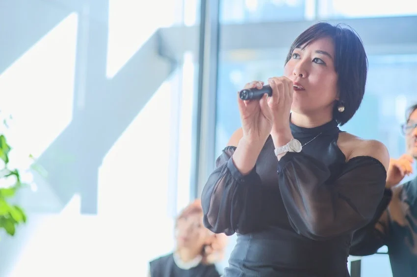 代表理事と思われる女性がスピーチする様子