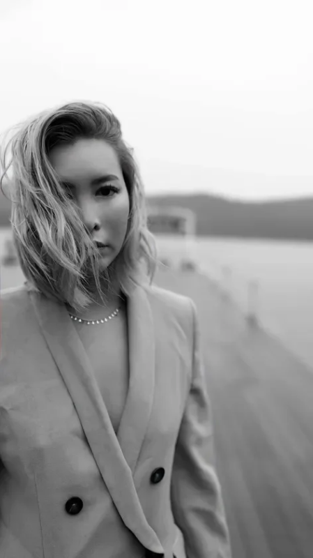 ブレザーを着用し、ネックレスをつけた女性のモノクロポートレート