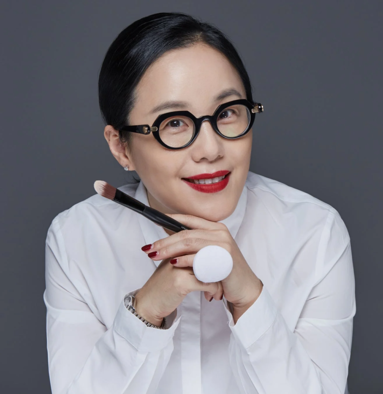化粧筆と白いパフを持つアジア人女性