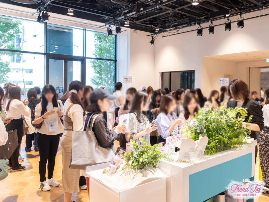 LIPS Trend Fes FOR CREATORSの会場で、多くの女性参加者が製品展示ブースに集まり、商品を見たり情報交換をしたりしている様子