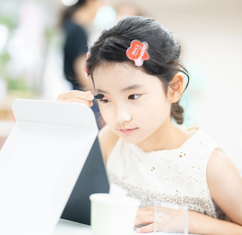鏡を見ながらアイシャドウを塗る少女