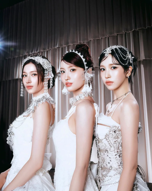 白い豪華なドレスと煌びやかなアクセサリーを身につけた3人の女性アイドル