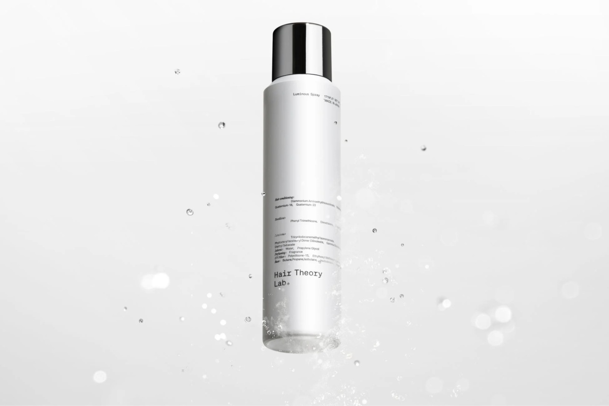 白い背景に、黒いキャップのヘアスプレーボトル「Luminous Spray Hair Theory Lab.」が水しぶきと共に写る画像