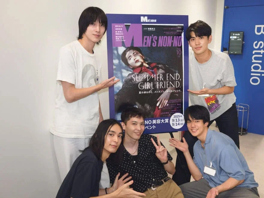 メンズノンノのポスターを囲む5人の男性が笑顔でポーズをとる集合写真。ポスターには「SUMMER END, GIRL FRIEND.」や「NO 美容大賞」の文字が見える。