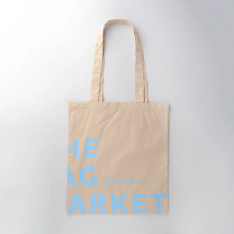 水色の文字で「THE BAG MARKET」と書かれたベージュ色のトートバッグ