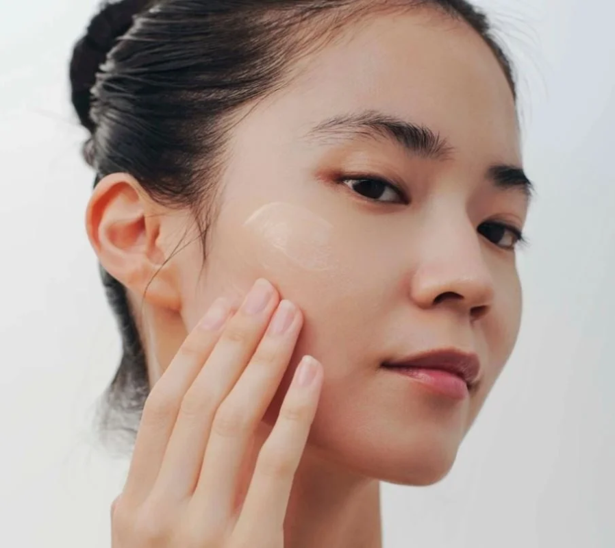 女性が顔に化粧品を塗っている様子