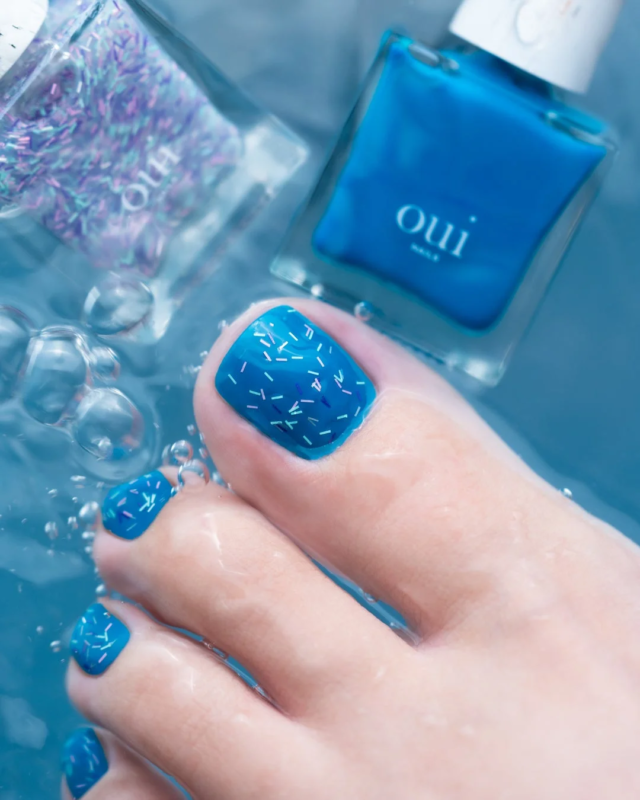 青いペディキュアの足とネイルポリッシュ