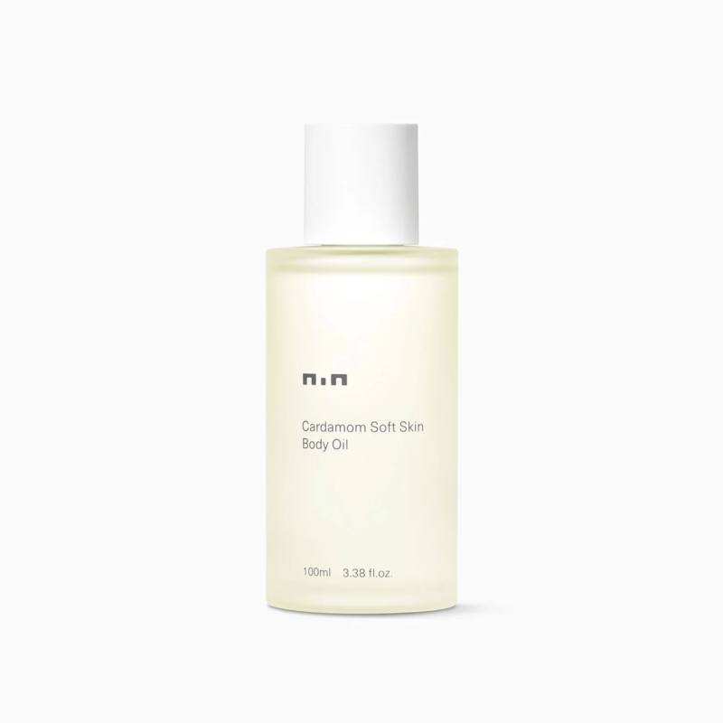 白い背景に、フロスト加工されたボトルに入った「Cardamom Soft Skin Body Oil」が写っています。白いキャップが特徴的な、ミニマルなデザインのボディオイルです。