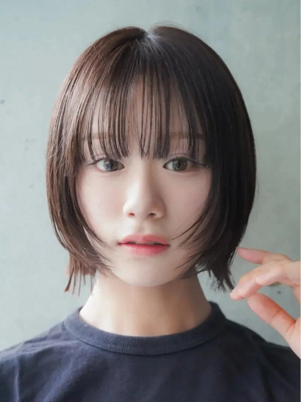 茶色のショートボブヘアと前髪が特徴の若い女性