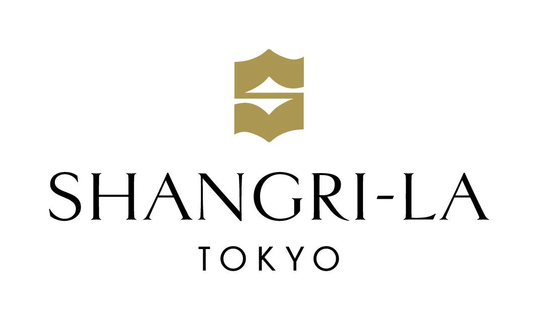 シャングリ・ラ 東京のロゴマークです。金色の上品なエンブレムと「SHANGRI-LA TOKYO」の文字が白地に配置されており、高級ホテルのブランドイメージを伝えています。