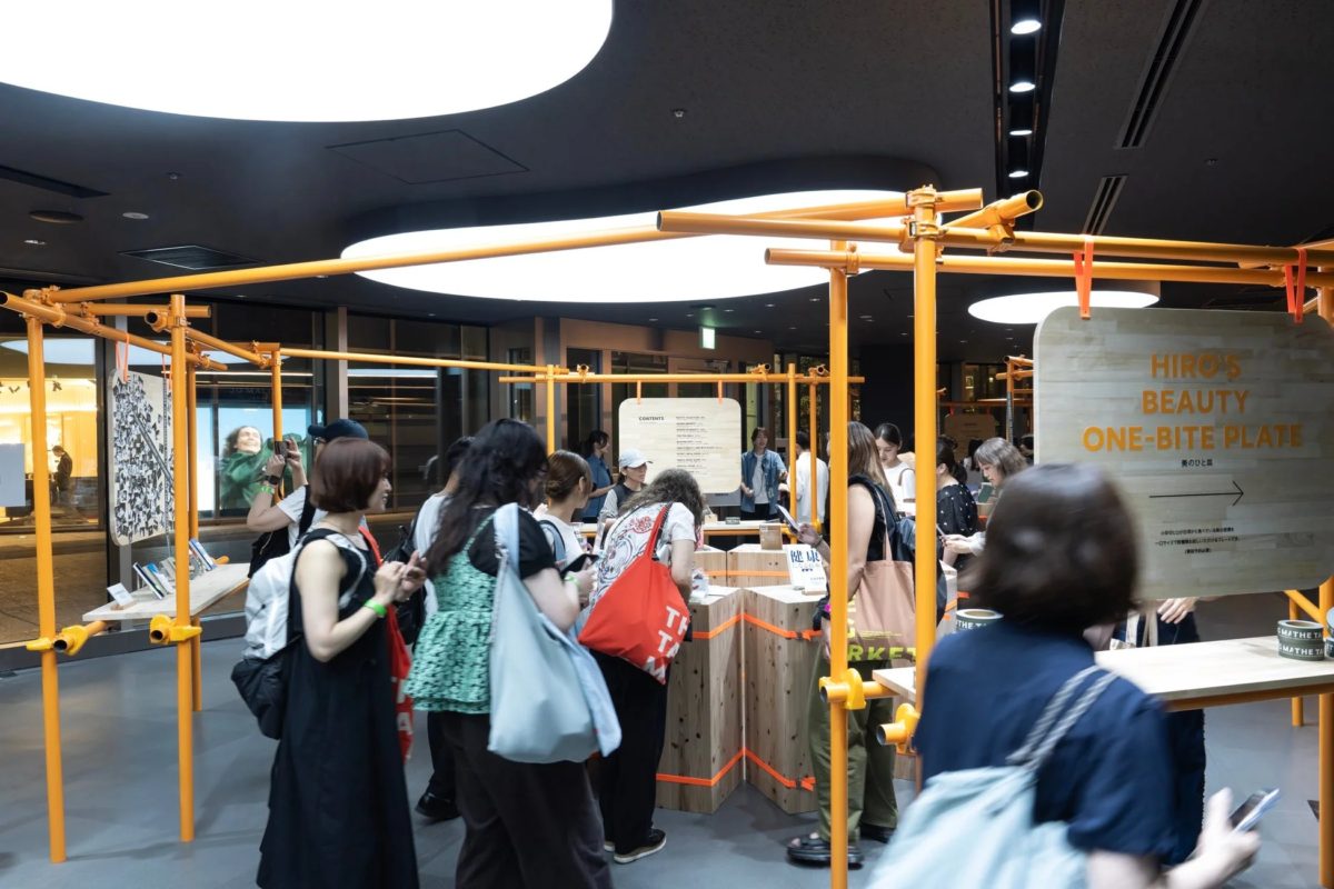 オレンジ色のフレームと木製ディスプレイが特徴的なイベント会場